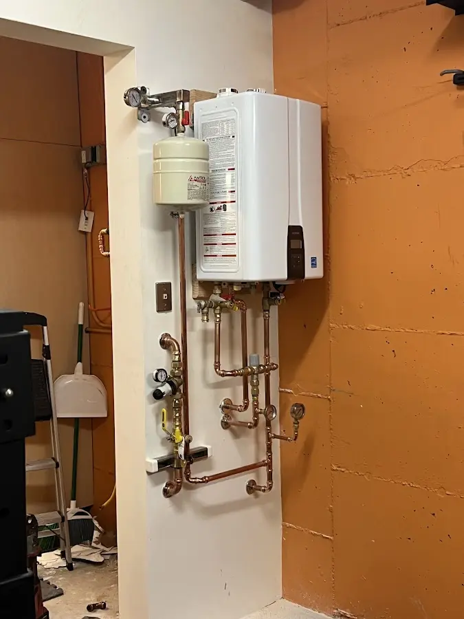 Plumbing technician inspecting water heater connections in Tarrytown